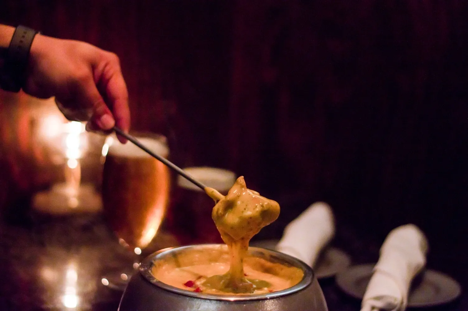 A person stirring something in a pot with some kind of liquid.